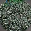 String of green beads on a dark surface