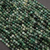 Close-up of green and black beads on a dark surface