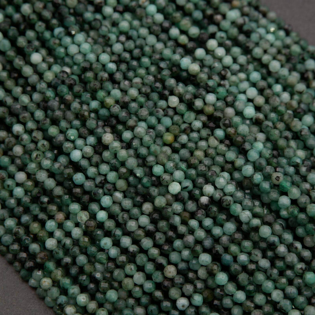 Green faceted round beads with a mix of emerald green hues.