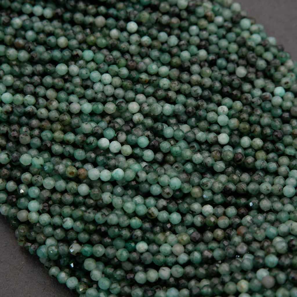 Green faceted round beads with a mix of emerald green hues.