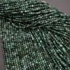 Green faceted round beads with a mix of emerald green hues.