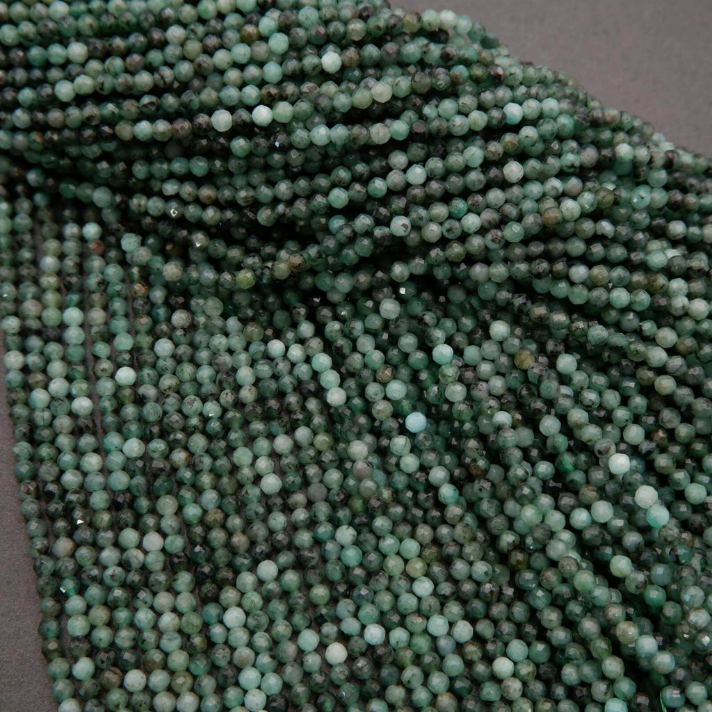 Green faceted round beads with a mix of emerald green hues.
