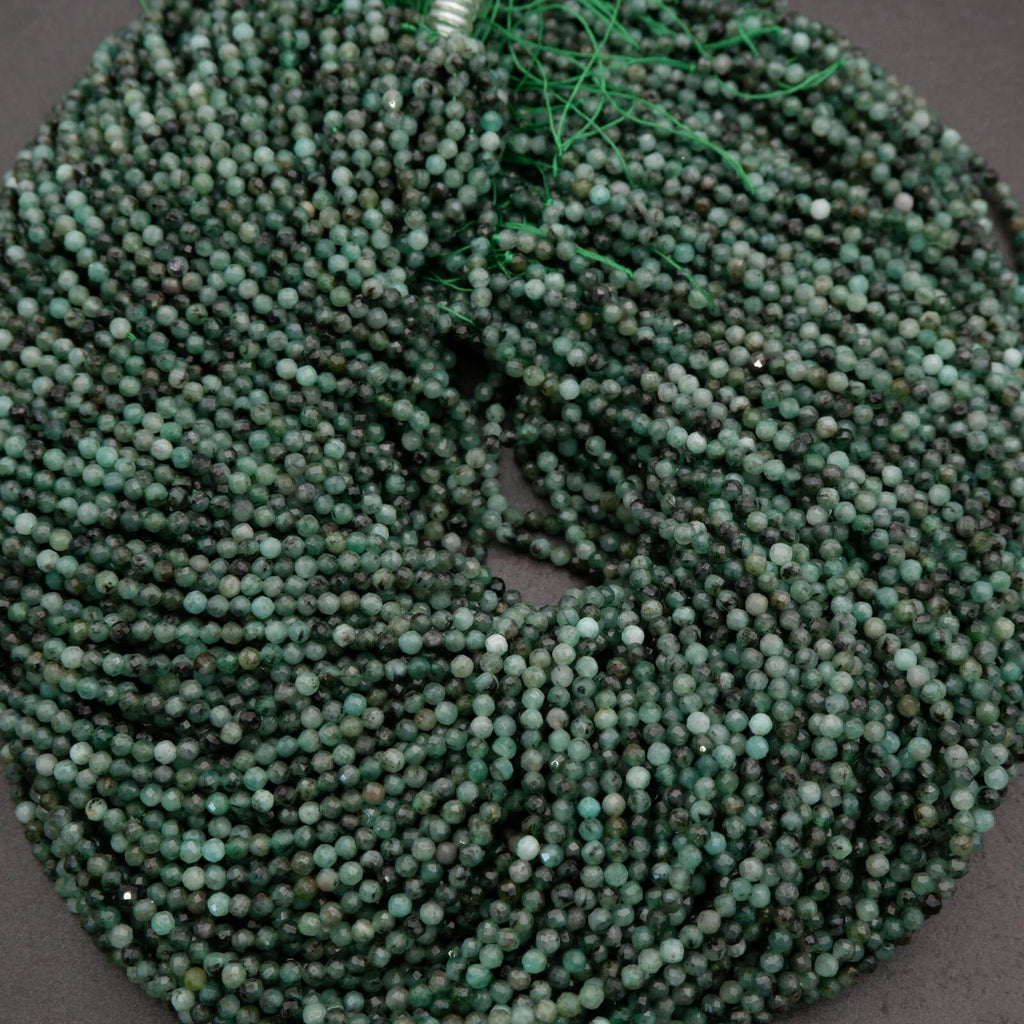Green faceted round beads with a mix of emerald green hues.