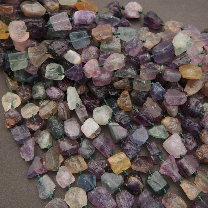 Close-up of multicolored gemstone beads on a gray background