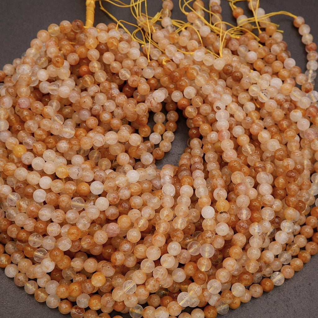Close-up of a string of small, round, multicolored beads on a dark background.