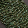 Close-up of green beads on a string against a dark background