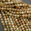 Yellowish green round beads with brown banding.