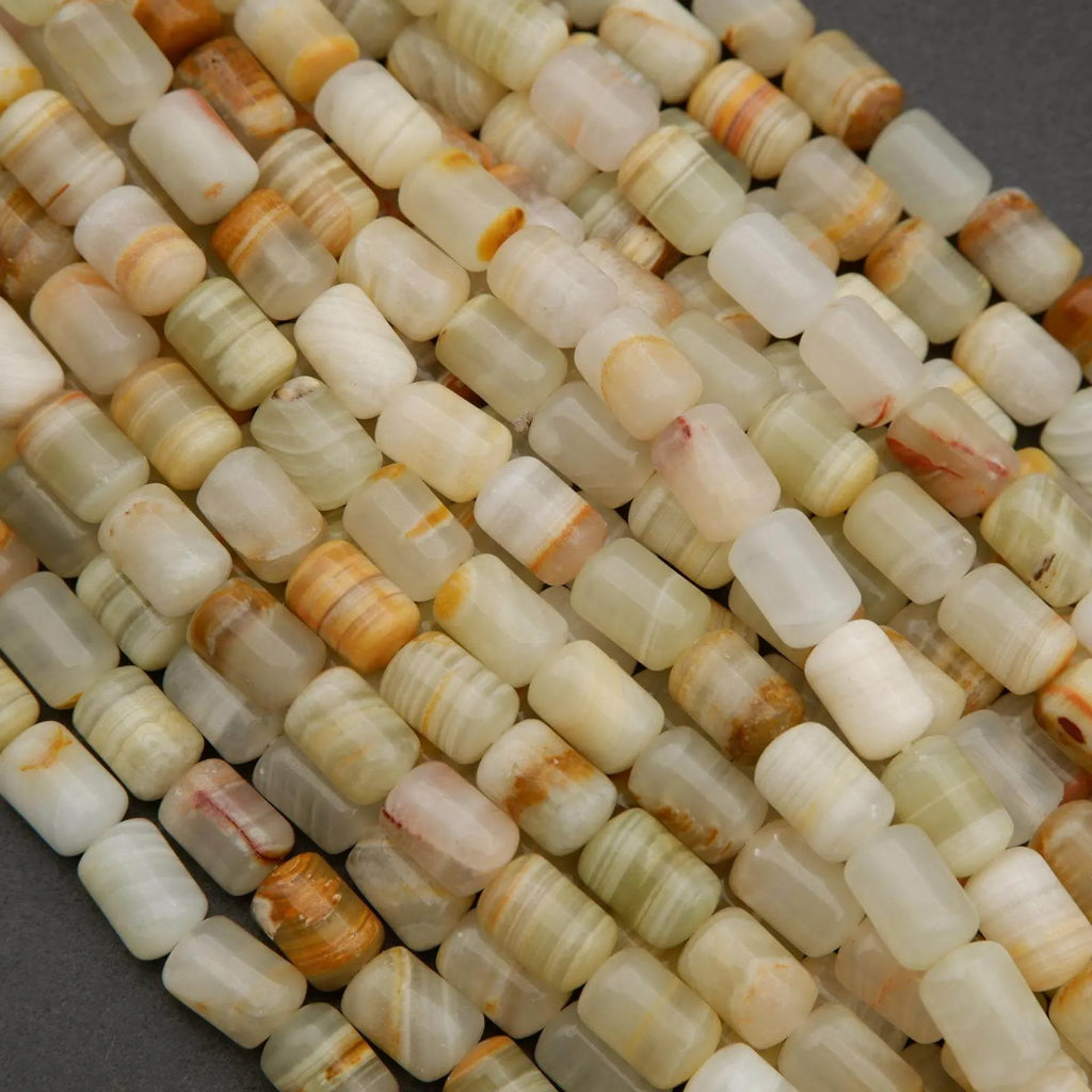 Barrel-shaped calcite beads in soft green, cream, and honey hues with subtle stripes