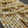 Striped calcite beads in pale green, beige, and golden tones for jewelry making
