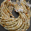 Striped calcite beads in pale green, beige, and golden tones for jewelry making