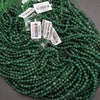 Green beads with price tags on a dark surface