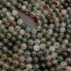 Close-up of green and white beads on a gray background