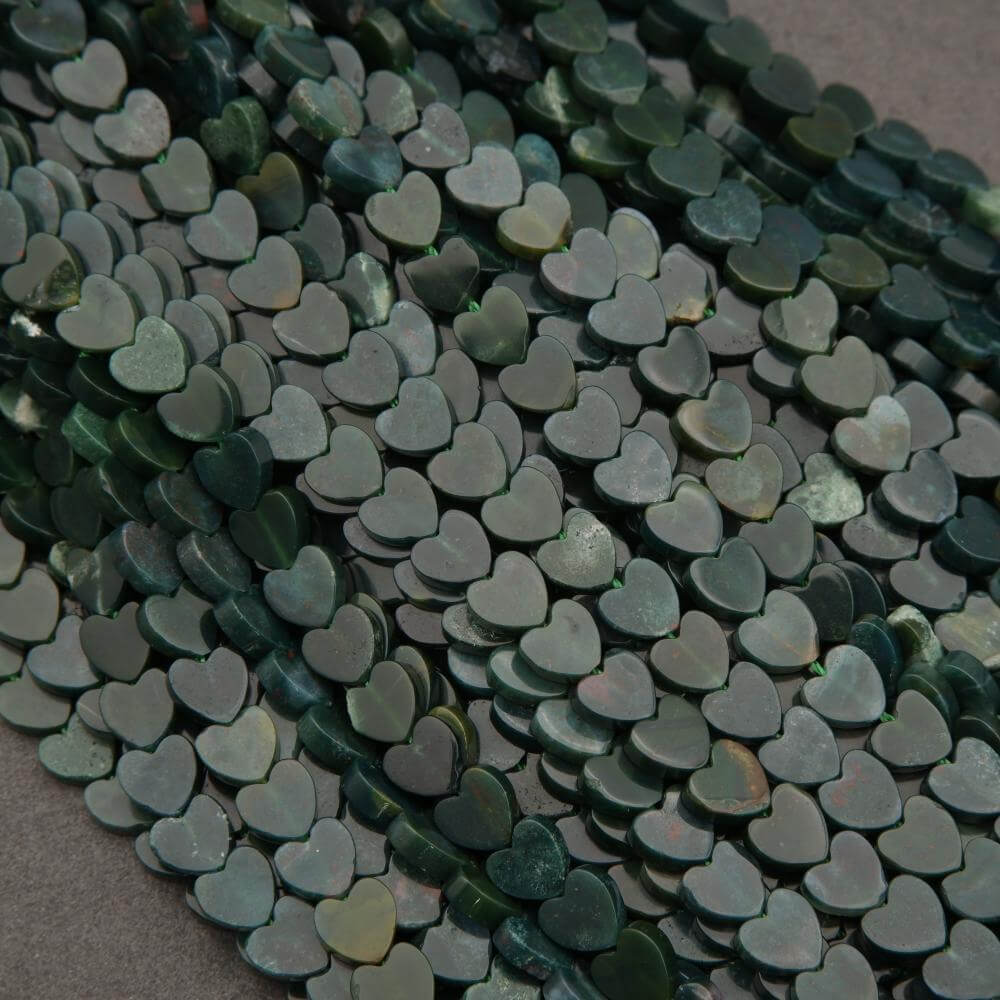 Close-up of green heart-shaped beads on a dark background
