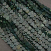 Close-up of green heart-shaped beads on a dark background