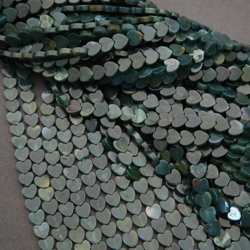 Close-up of heart-shaped green beads on a gray background