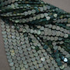 Close-up of heart-shaped green beads on a gray background
