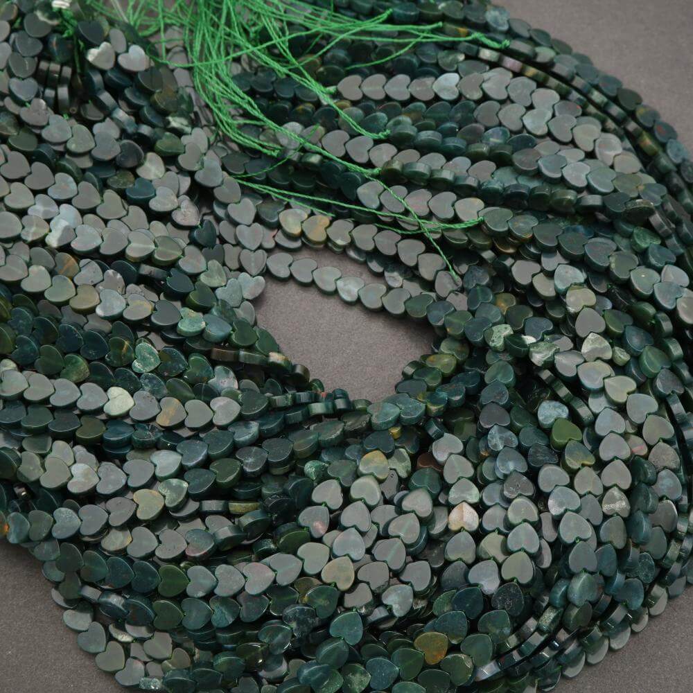 String of green heart-shaped beads on a gray background