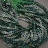 String of green heart-shaped beads on a gray background