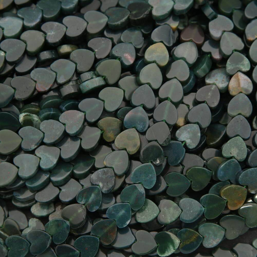 Close-up of heart-shaped green stones with a dark background
