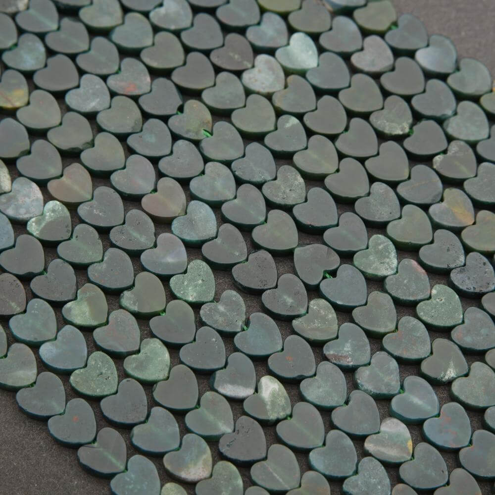 Close-up of green heart-shaped stones on a dark surface