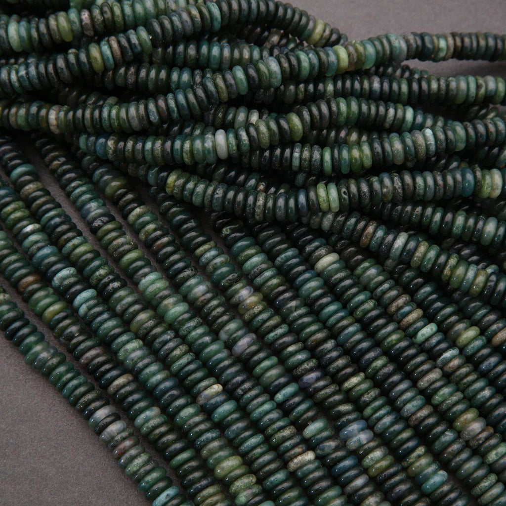 Close-up of green and blue beads on a gray background