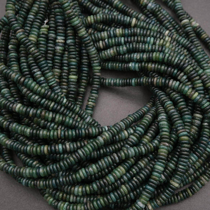 Close-up of green heishi beads on a gray background