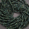 Close-up of green heishi beads on a gray background