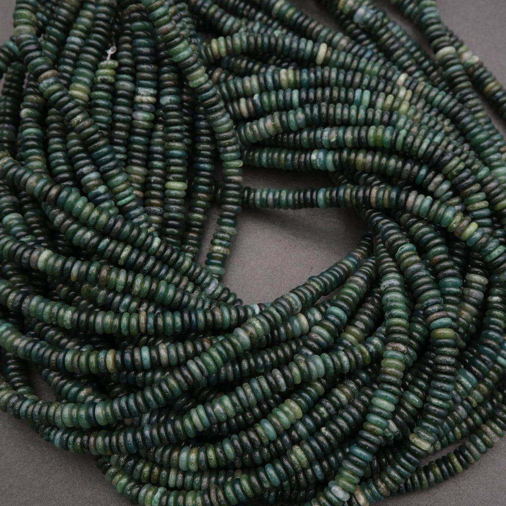 Close-up of green heishi beads on a gray background