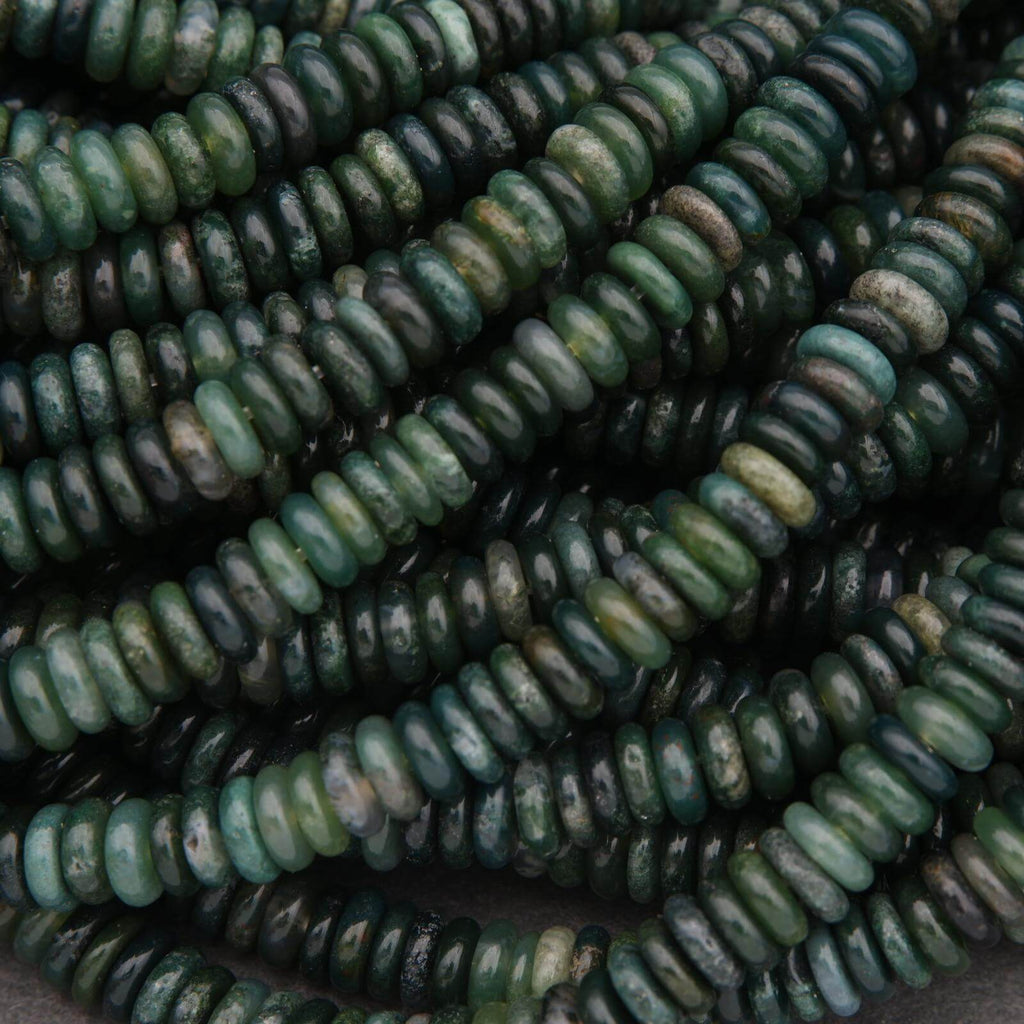 Close-up of green and brown beads on a dark background