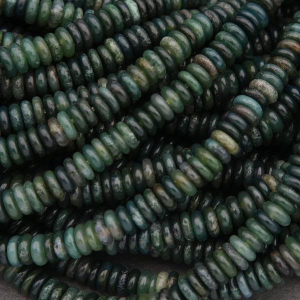 Close-up of green and brown beads on a dark background