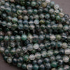 Close-up of green and white marbled beads on a dark background