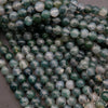 Close-up of green and white marbled beads on a gray background