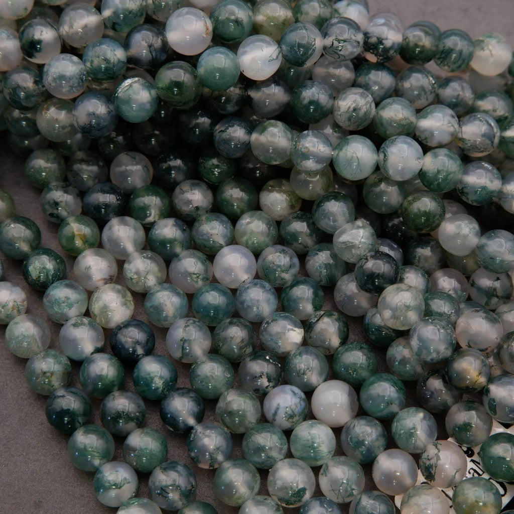 Close-up of green and white marbled beads on a gray background