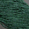 Tiny faceted green beads on a string.
