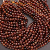 Close-up of a string of dark brown beads on a gray background