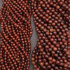 Two strands of brown beads on a gray background
