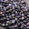 Close-up of purple and gray pebbles on a neutral background