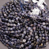 String of purple beads with visible labels on a gray surface