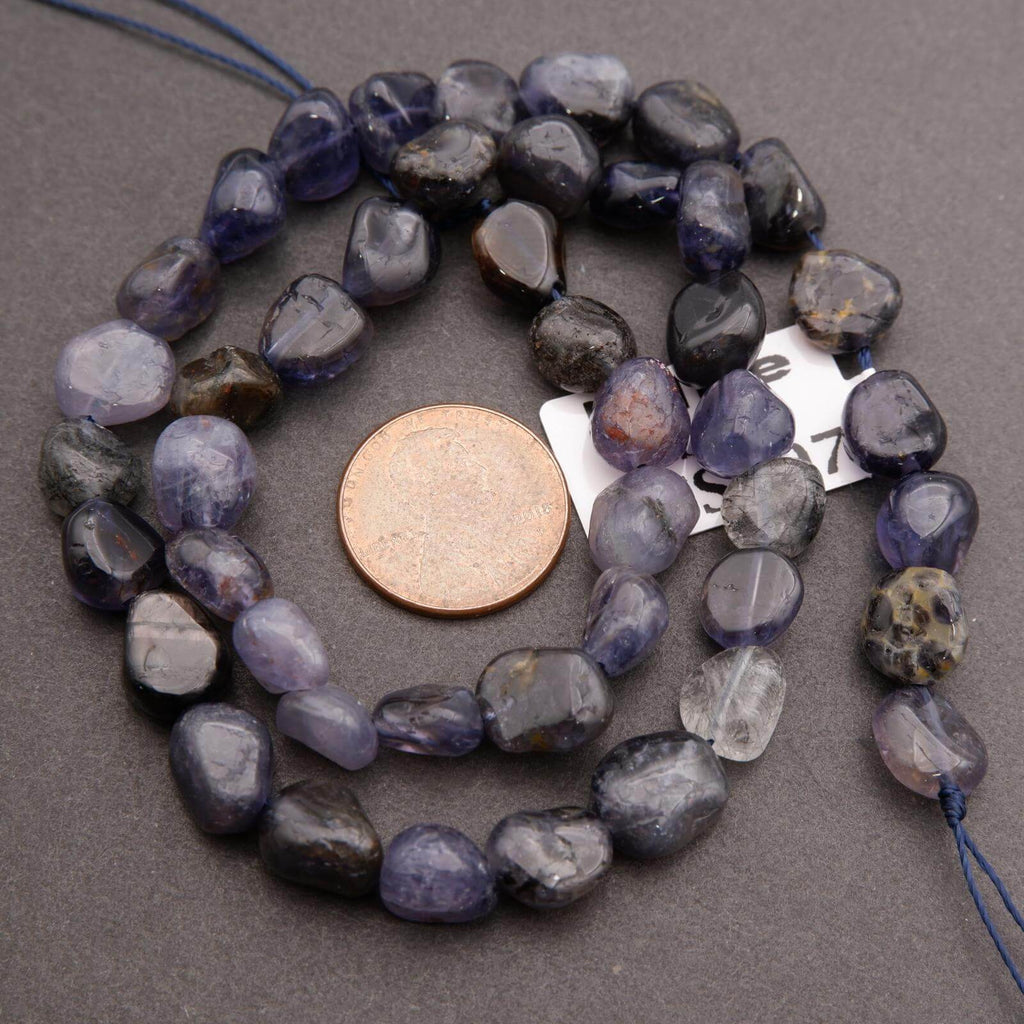 String of purple and gray beads with a penny for scale on a gray background