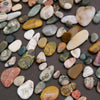 Assorted colorful pebbles on a dark surface