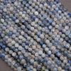 Strands of mixed-tone kyanite beads showing icy blue hues and organic mineral patterns.