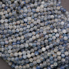 Close-up of pale blue and gray kyanite gemstone beads with earthy inclusions.