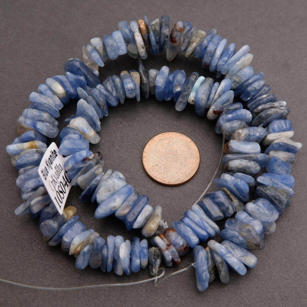 Blue stone beads on a gray background with a penny for scale