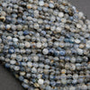 Close-up of blue and gray faceted beads on a dark background