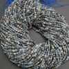 String of blue and gray beads on a gray surface