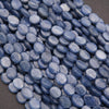 Close-up of blue oval beads on a dark background