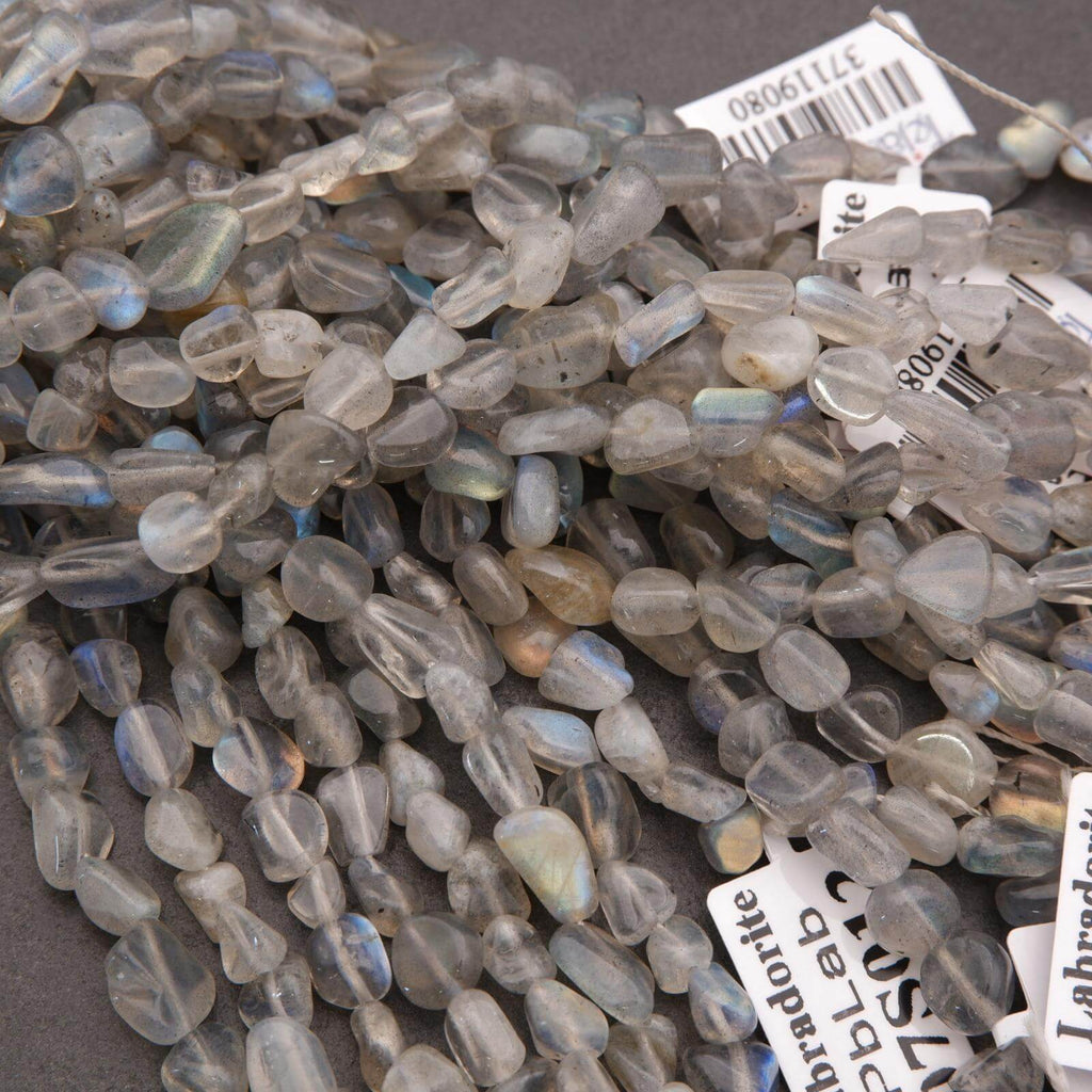 Close-up of labradorite beads with visible brand labels on a dark background