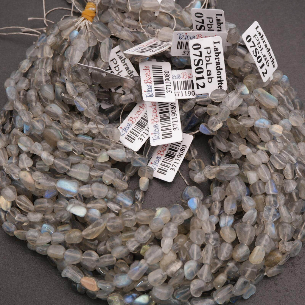 String of labradorite beads with labels on a dark background