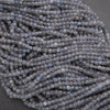 Close-up of a string of small blue beads on a dark background
