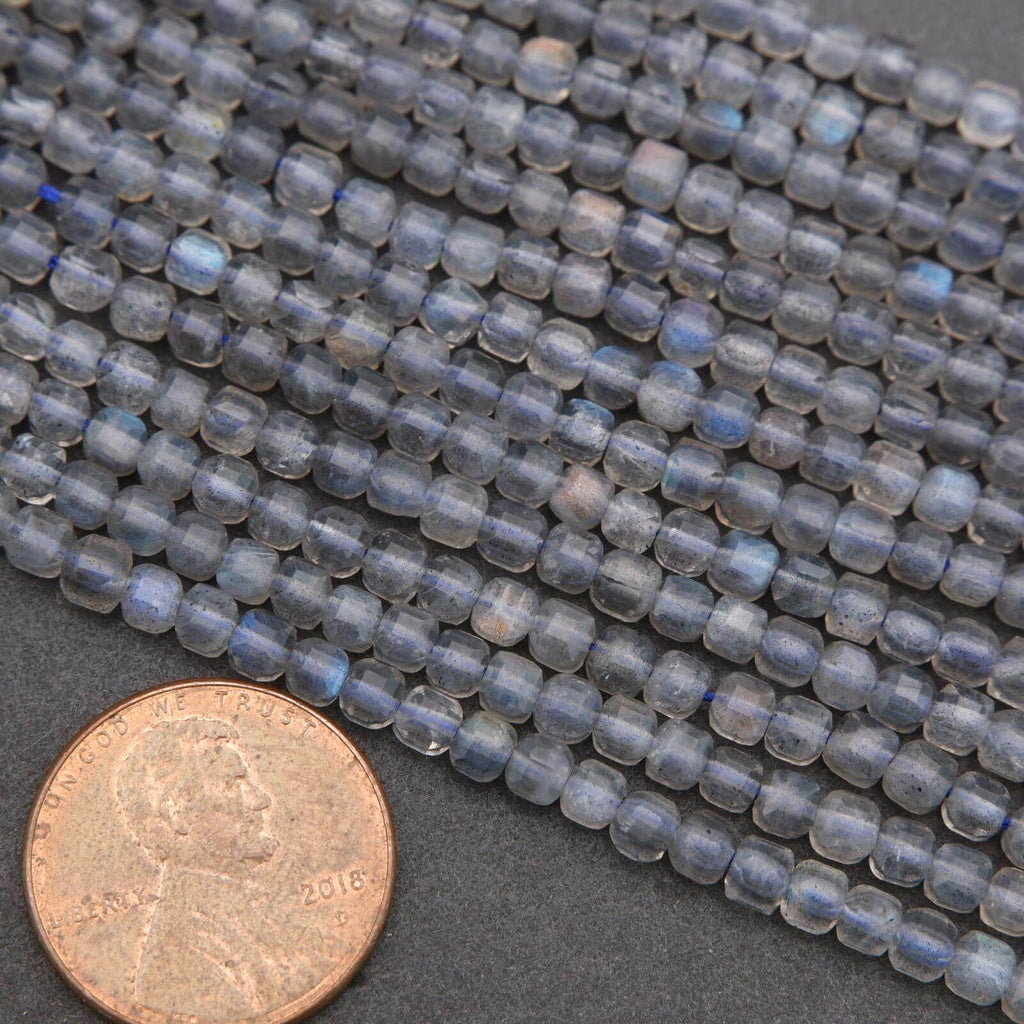 Close-up of blue beads with a penny for scale on a dark surface